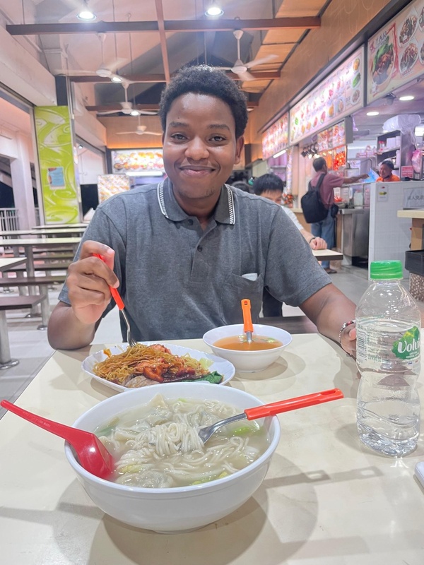 Mwathi eating food in Singapore